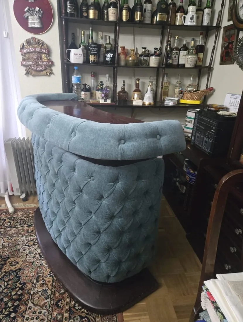 Mueble-bar tapizado en chesterfield azul, toma lateral del trabajo terminado