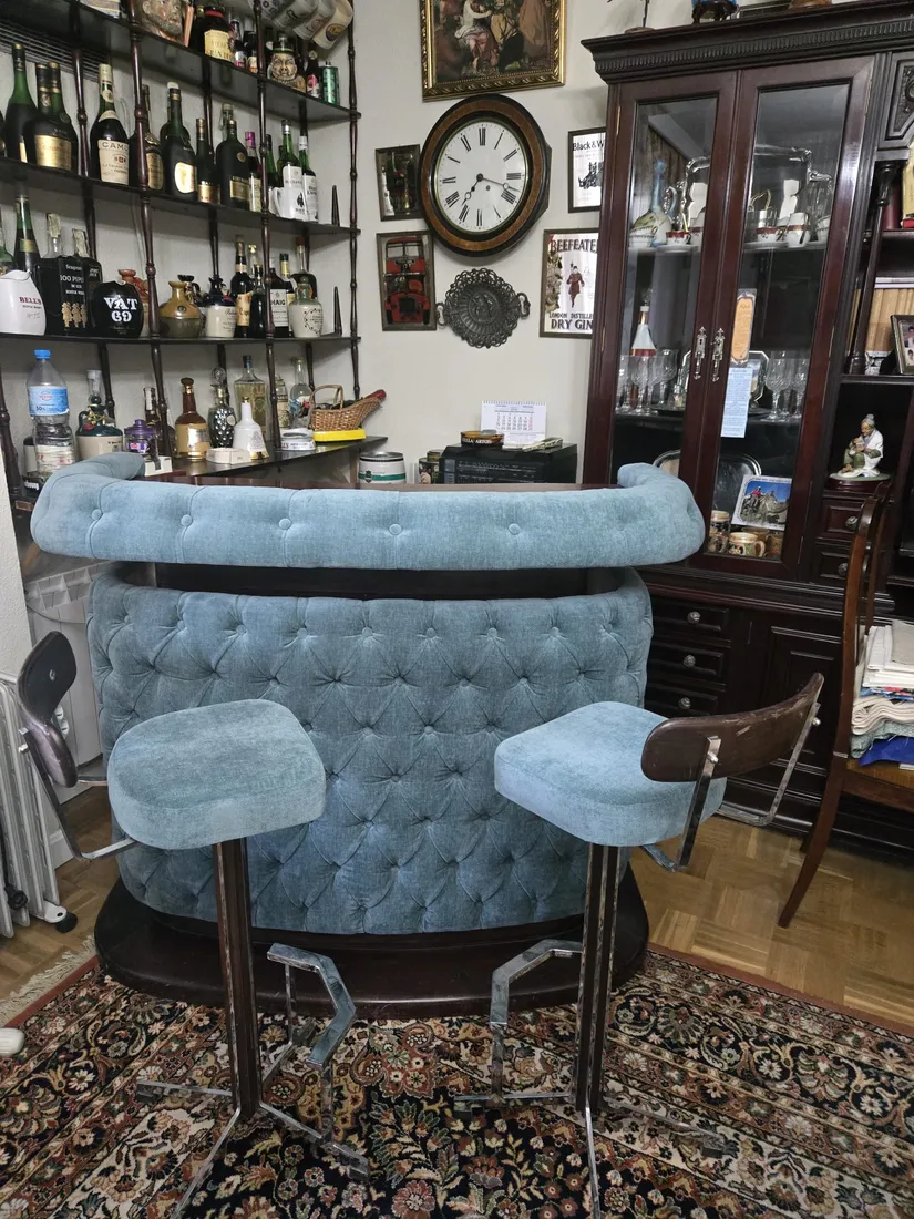 Barra de bar chesterfield azul con taburetes a juego, toma completa
