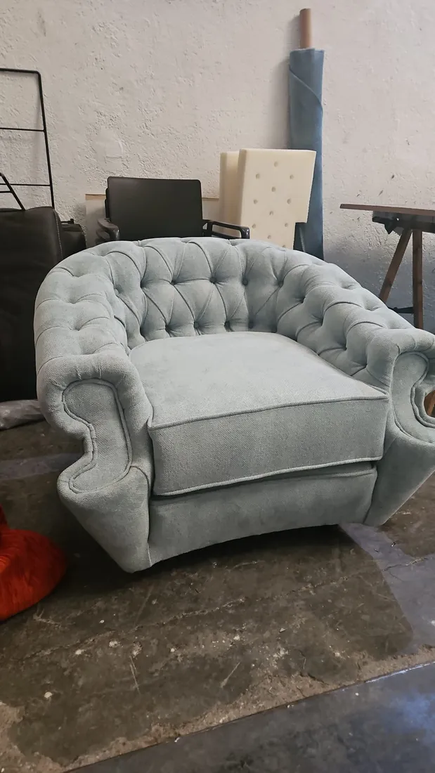 Butaca chesterfield azul recién terminada en el taller de tapicería