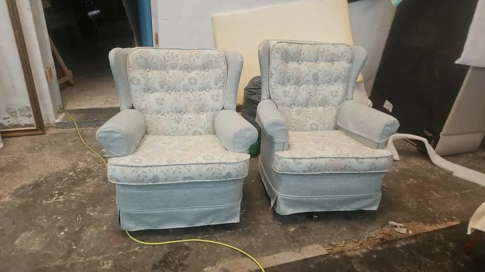 Dos butacas orejeras tapizadas en tela floral azul y blanco, trabajo terminado en taller