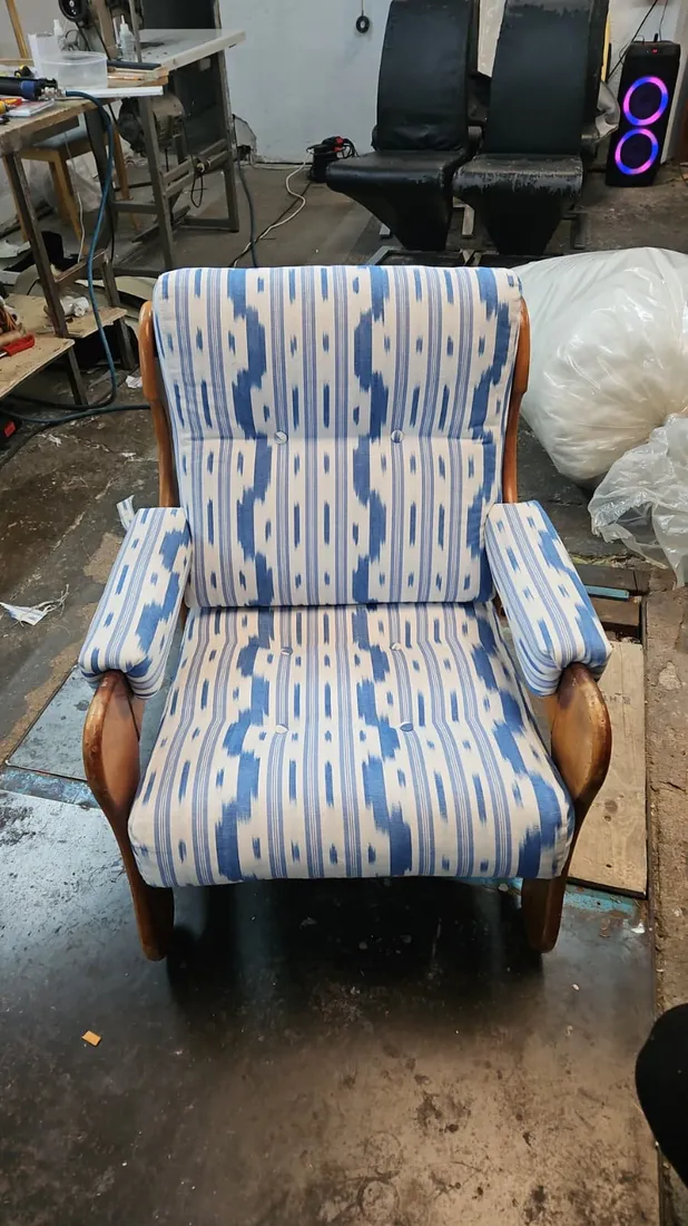 Butaca tapizada en tela ikat azul y blanco con estructura de madera