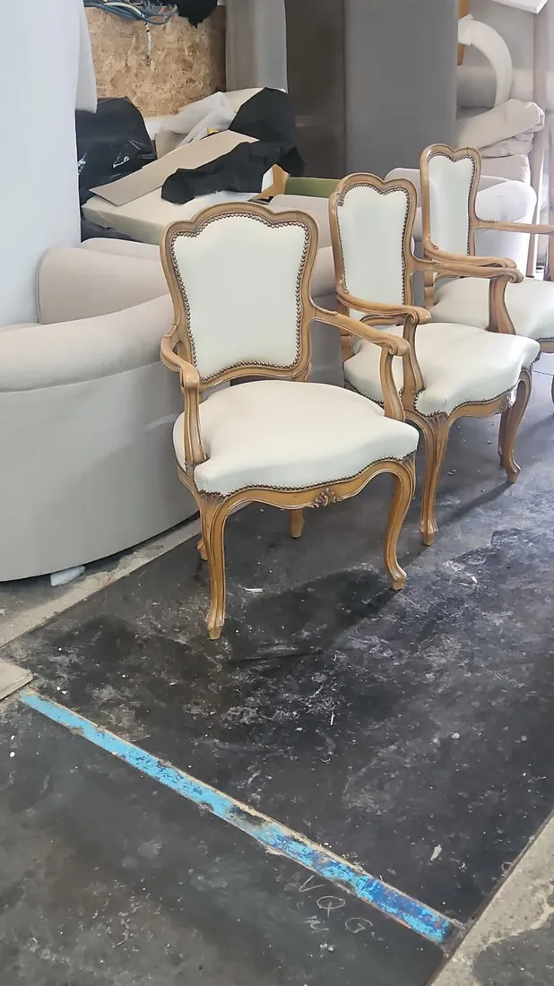 Tres sillas estilo Luis XV tapizadas en blanco crema con tachuela dorada, aptas para hostelería