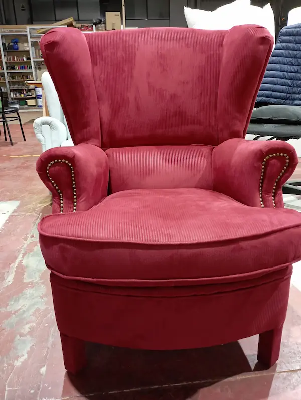Sillón tapizado en tela roja restaurado en el taller